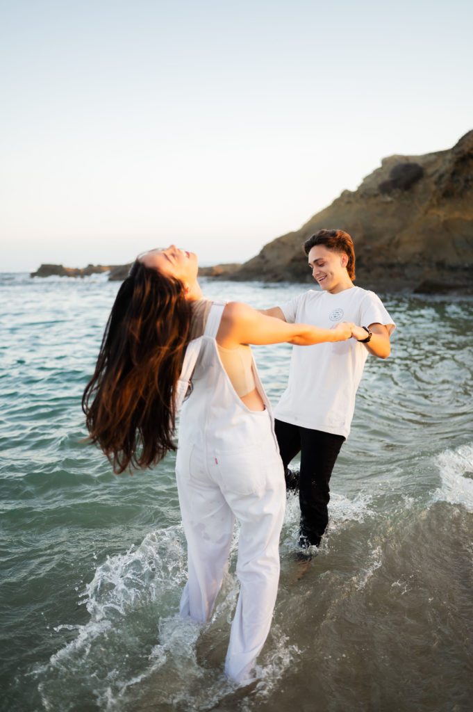 Couple plays in the water at Laguna Beach engagement session.