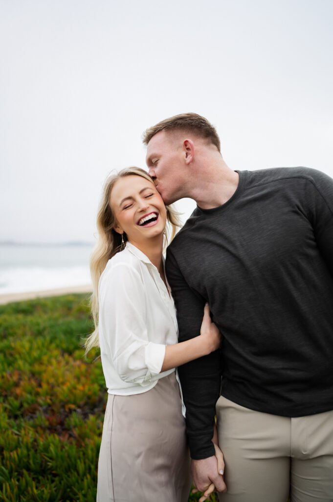 Man kisses his fiance during half moon bay cliffside engagements in san francisco, california
