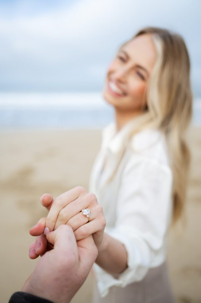 Fiance shows off unique engagement ring during engagement session with destination wedding photographer and videographer.