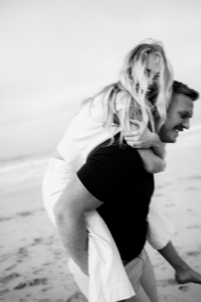 Half moon bay engagements at the beach with couple doing piggyback ride posing prompts
