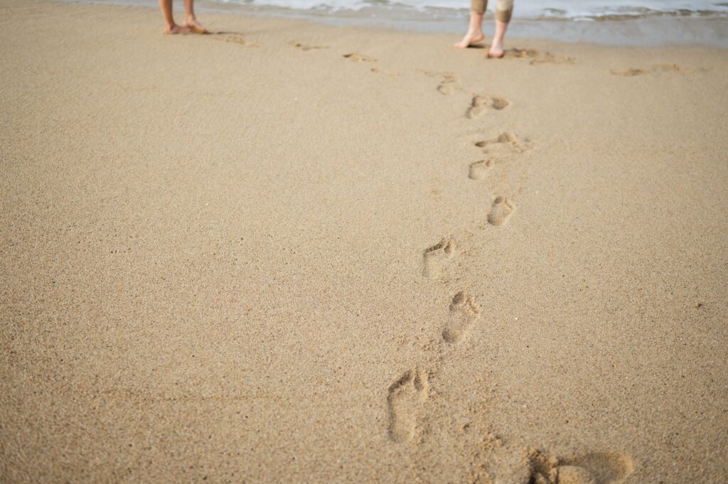 Footprints in the sand at Half moon bay engagements photoshoot