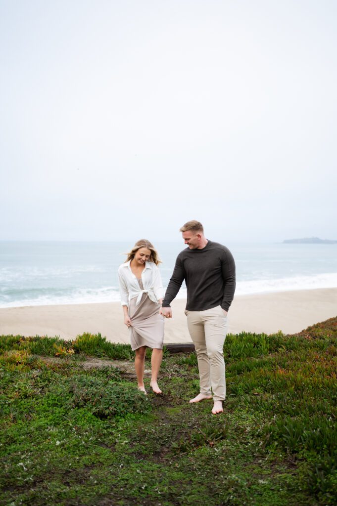 Engaged couple hold hands during half moon bay engagements with san francisco, california wedding photographer and videographer team.