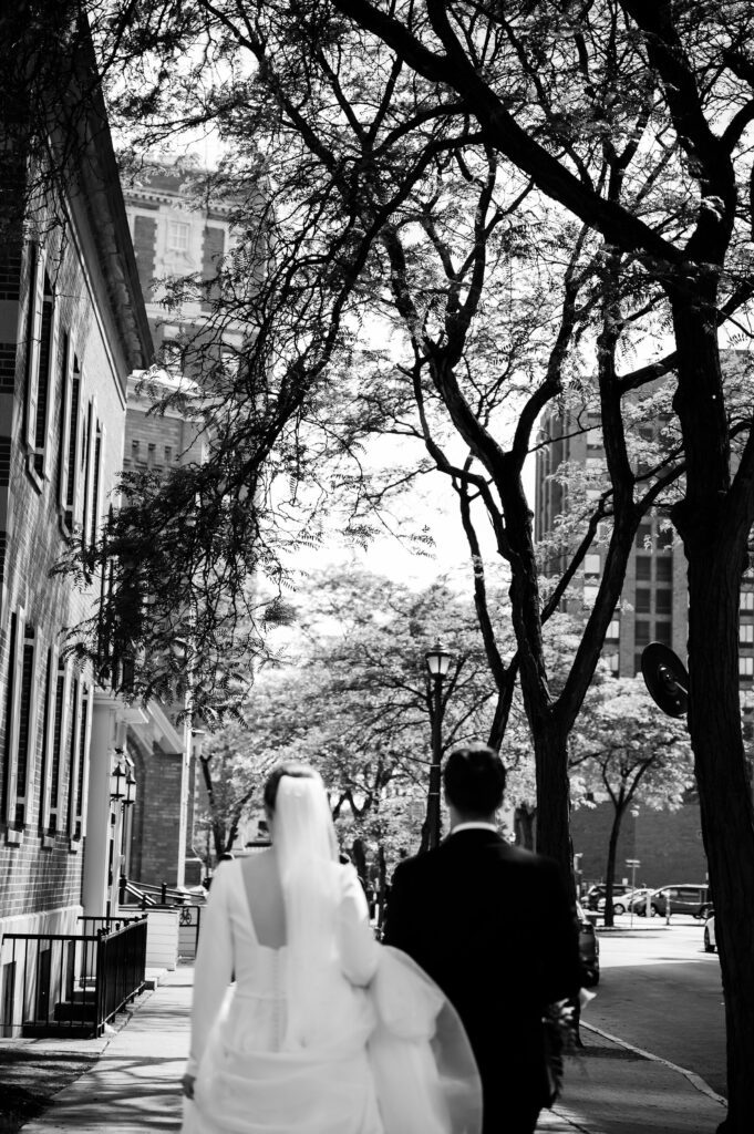 Married couple walking to venue in the city in downtown Syracuse New York after wedding ceremony.