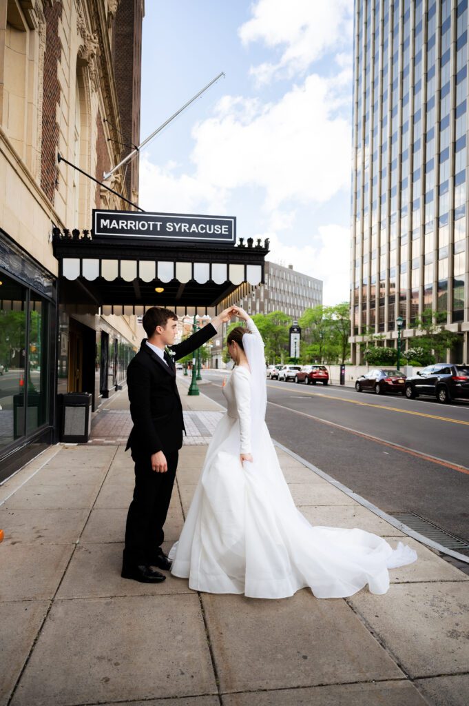 Bride and groom take portraits outside of their Syracuse Marriott Downtown wedding.