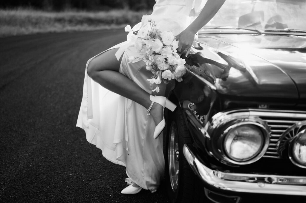 Classic vintage car bridals photoshoot by Dallas TX wedding photographer, white bouquet, groom's burgundy suit, black and white photos