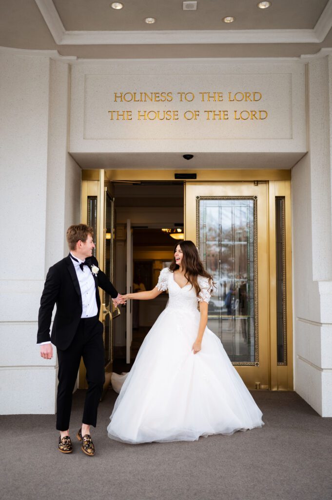 bride and groom exit from the doors of the brigham city utah temple