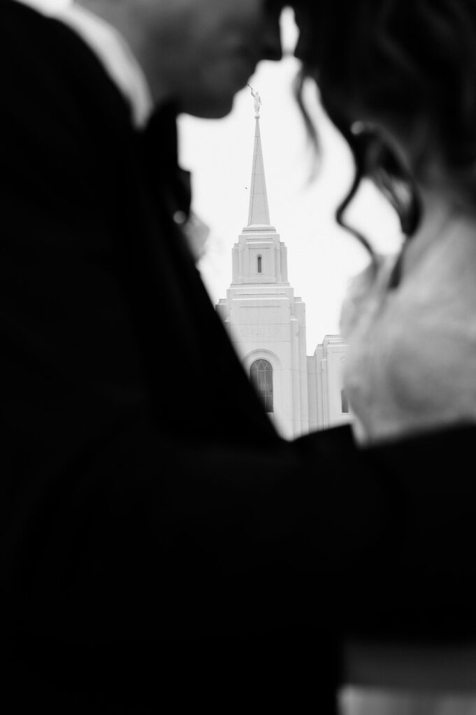 lds couple sharing a moment in front of their brigham city utah temple wedding
