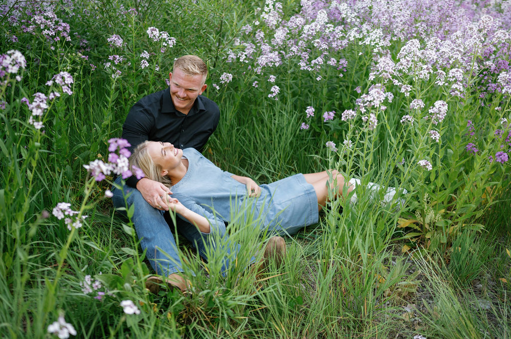 engagement poses, laying in wildflower field, couples outfit inspo