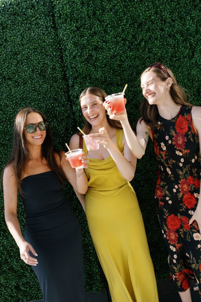wedding guests hold drinks during cocktail hour at the lane venue in san diego