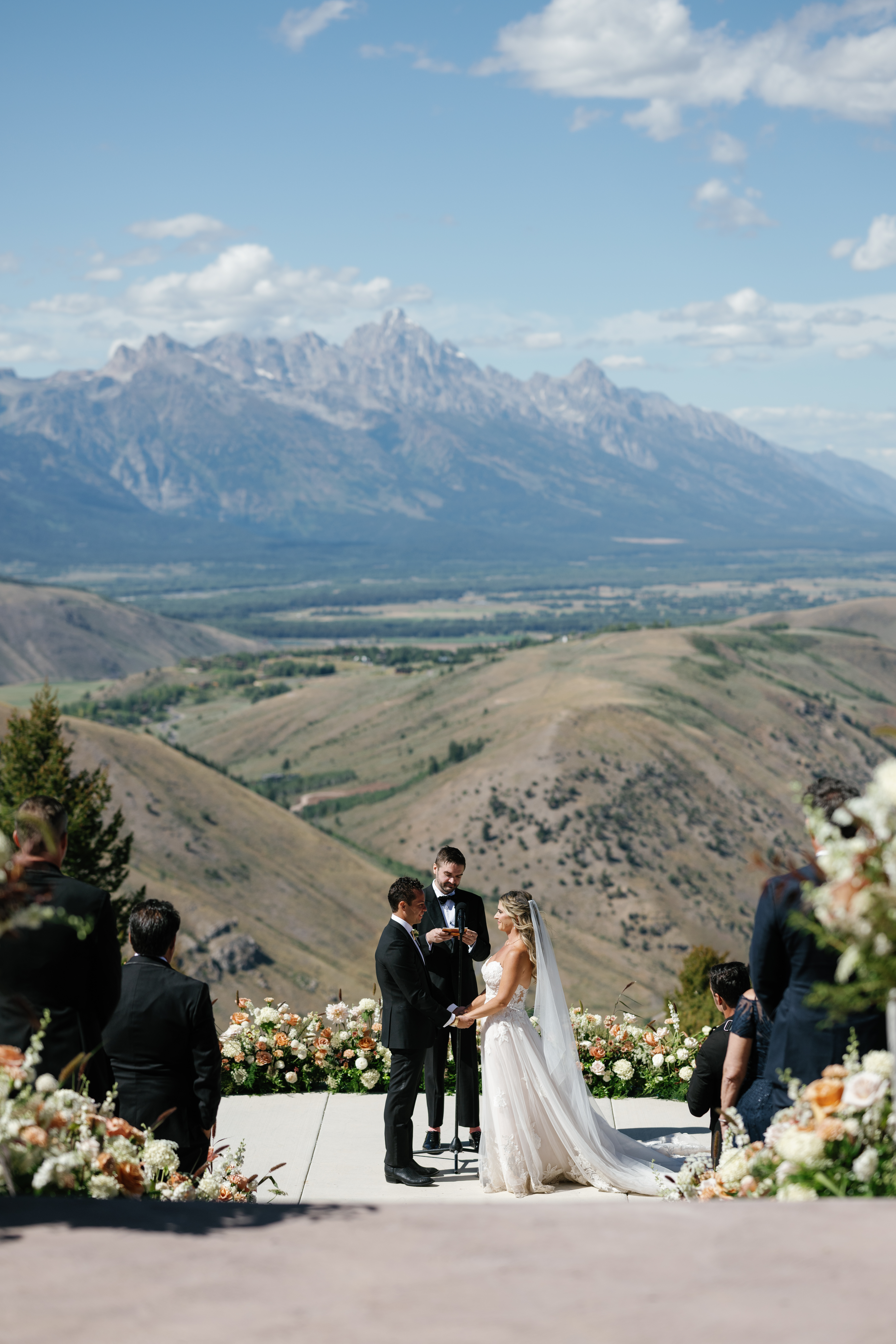 Couple during their outdoor ceremony with mountains as their backdrop during Snow King Jackson Wyoming wedding