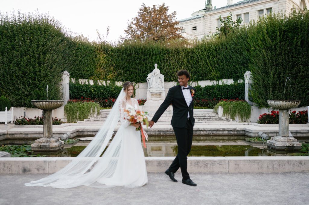 Couple walking hand-in-hand outdoors at Schoenbrunn Palace Vienna wedding