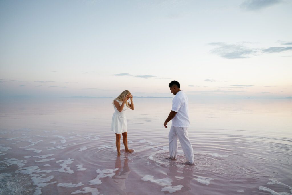 The couple standing in the water during Utah pink lake engagement photo shoot