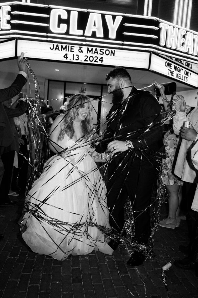 Black and white shot of couple walking outside of the Florida wedding venue clay theatre