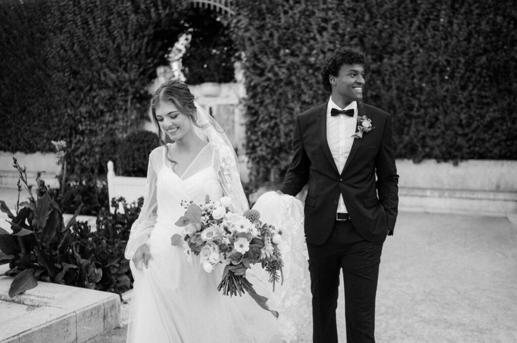 Black and white shot of bride and groom walking outdoors at Schoenbrunn Palace Vienna wedding