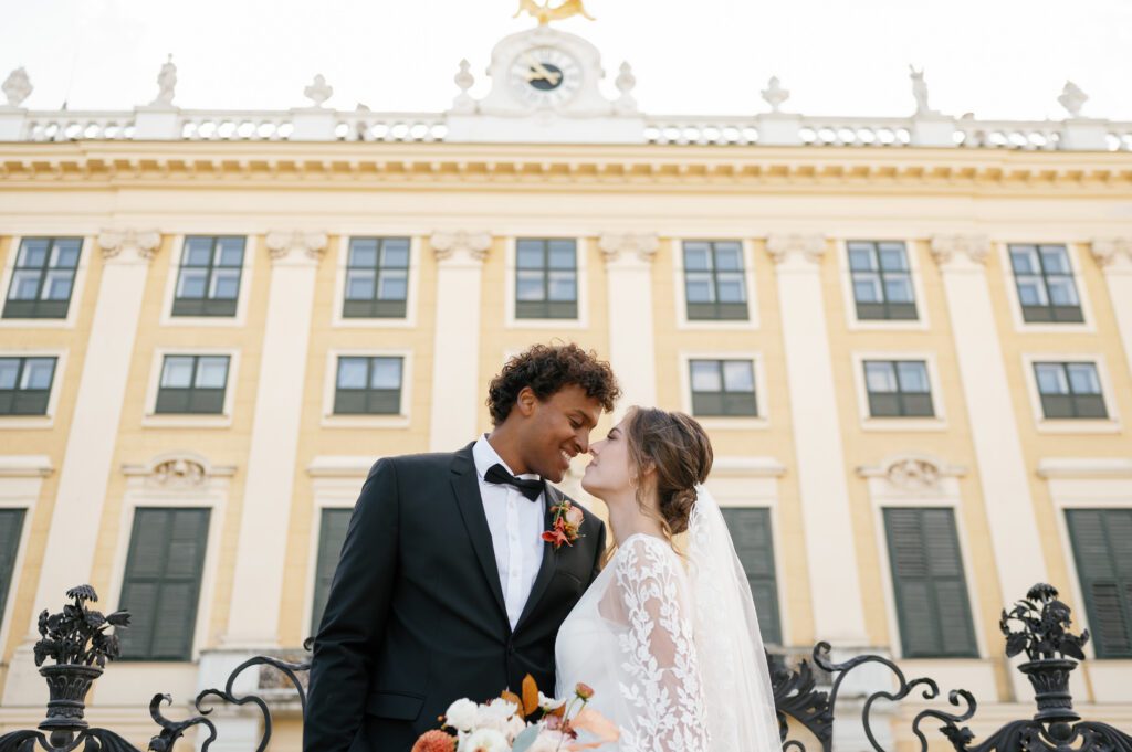 Bride and groom standing outside of Schoenbrunn Palace Vienna wedding venue