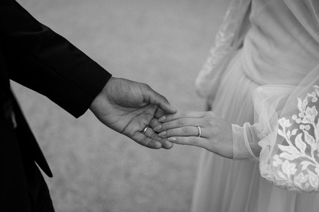 Close up black-and-white shot of couple holding hands at Schoenbrunn Palace Vienna wedding