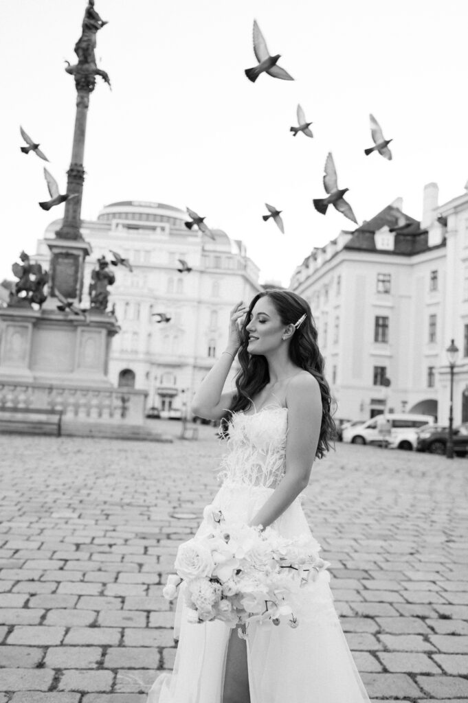 Black and white portrait of the bride with birds flying in the background captured by Vienna wedding photographer